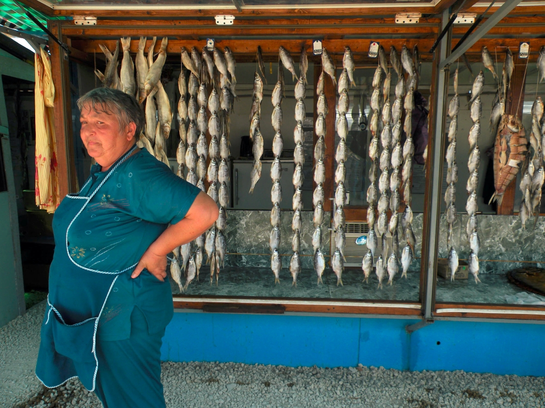 A woman sells dry, salted fish at a roadside market in Krasnodar